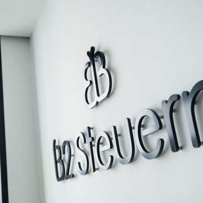Logo-Relief von B2 Steuern an einer Wand im Firmengebäude
